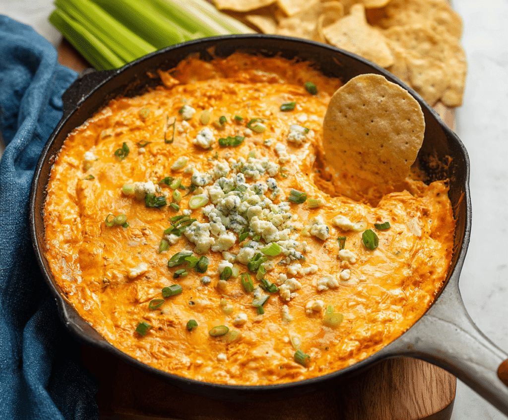 Creamy buffalo chicken dip with shredded chicken, melted cheese, and spicy buffalo sauce served in a savory dish.