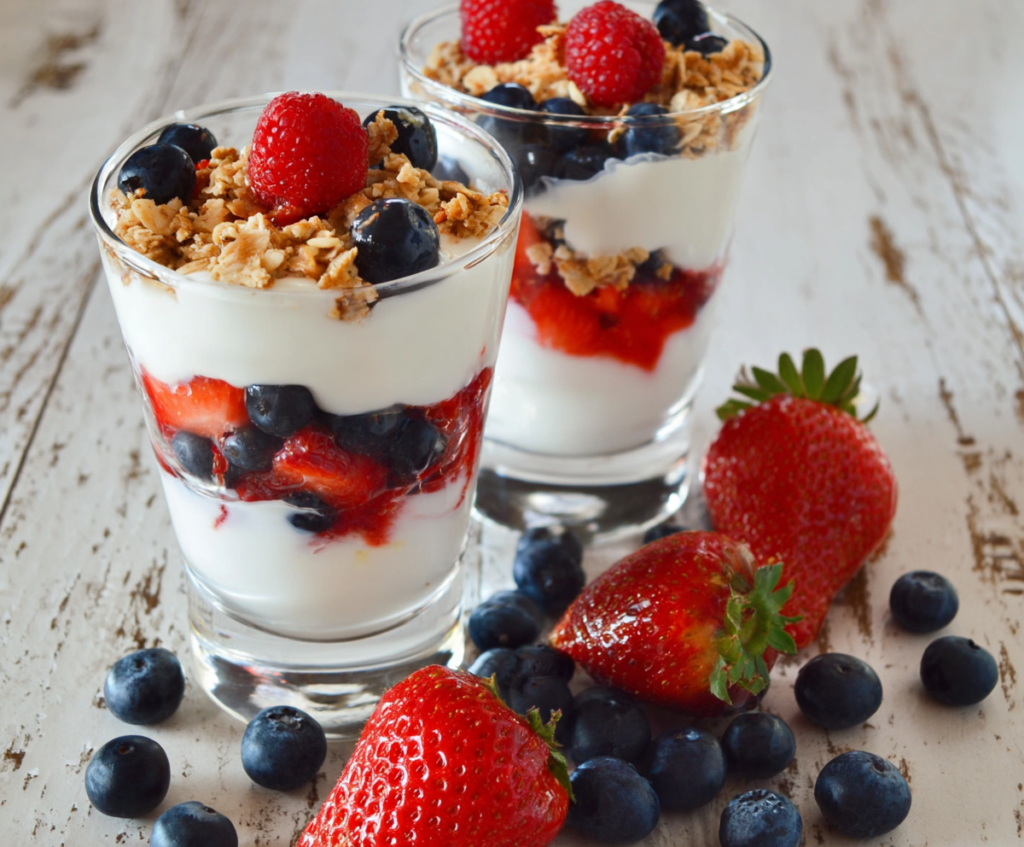 Fresh Greek yogurt berry parfait in a glass, topped with mixed berries and honey for a healthy breakfast.