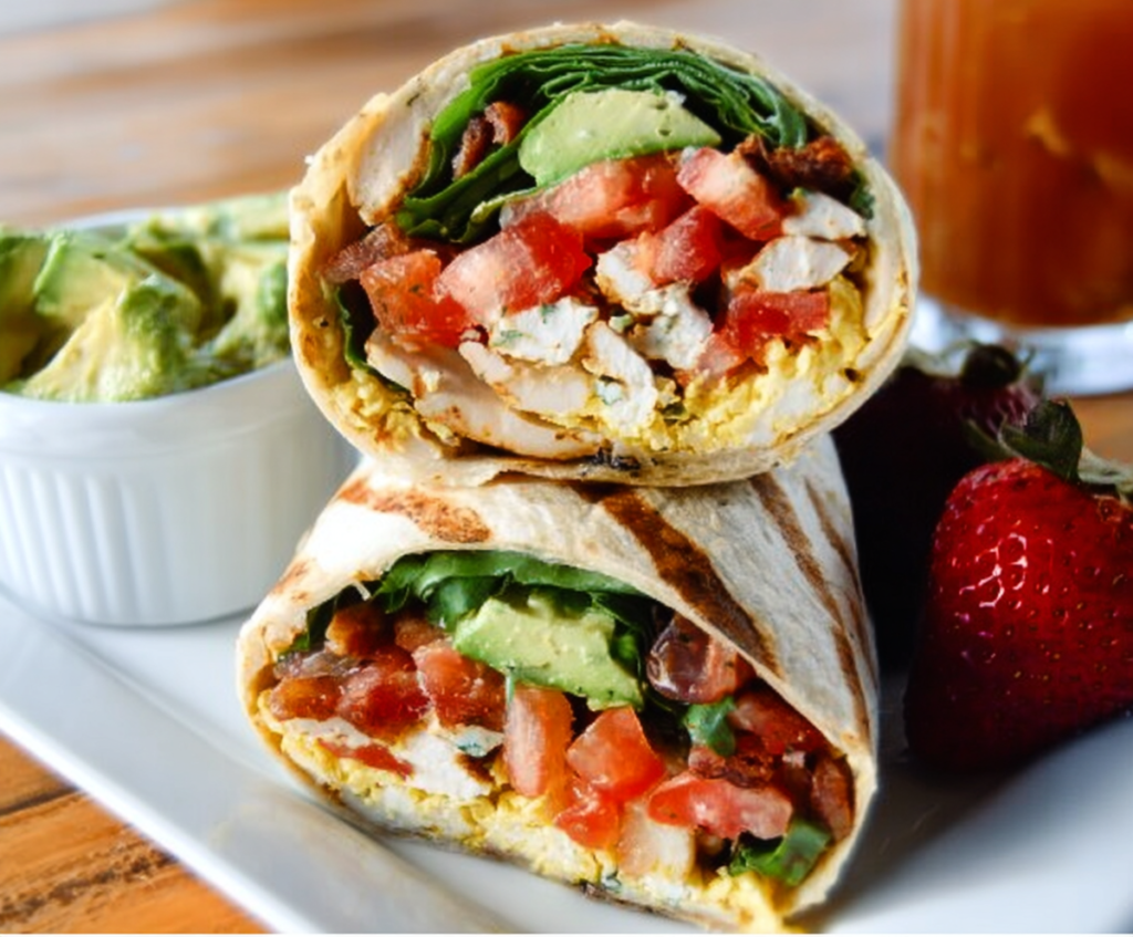 Healthy cottage cheese breakfast wrap with fresh vegetables in a whole wheat tortilla.